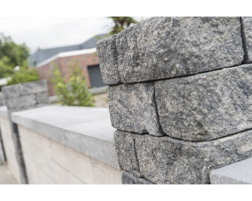 Muur van betonnen stenen in een buitenomgeving.