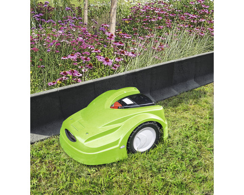 Groene robotmaaier op een gazon naast gazonrandstenen