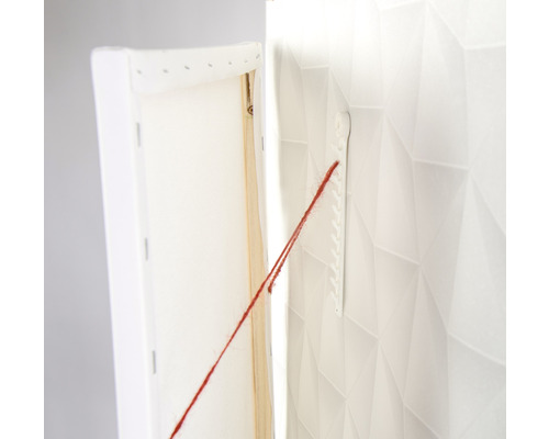 Leeg canvasdoek hangt met een koord aan een muurbevestiging