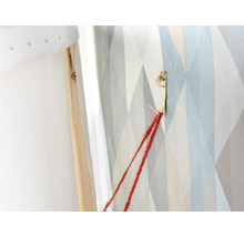 Detailopname van een ophangsysteem voor een foto aan een muur