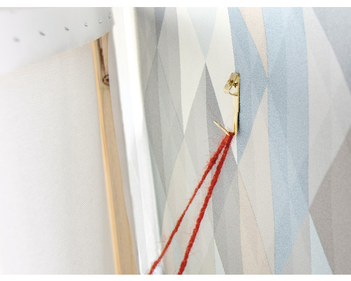 Detailopname van een ophangsysteem voor een foto aan een muur