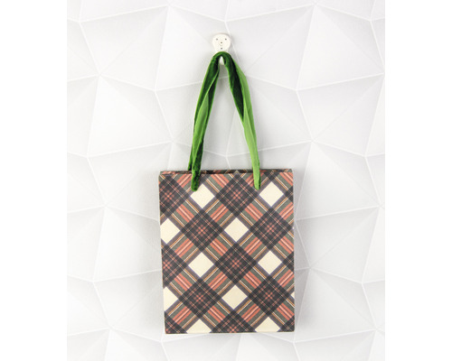 Boodschappentas met ruitpatroon en groene handvatten hangt aan een haak.