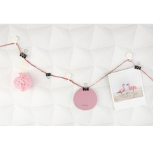 Decoratieve slinger met paperclips, foto en ornamenten aan een muur