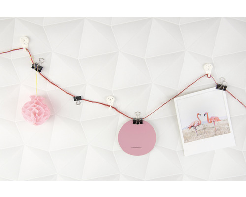 Decoratieve slinger met paperclips, foto en ornamenten aan een muur