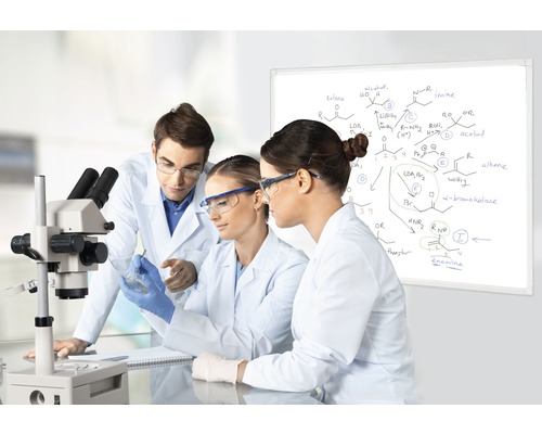 Scene in een laboratorium met drie wetenschappers, een microscoop en een whiteboard met chemische formules