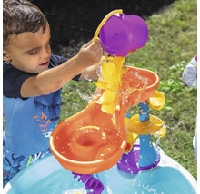 Jongen giet water in een waterglijbaan voor kinderen