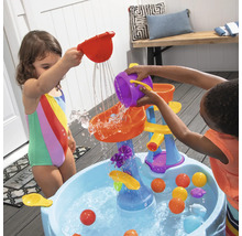 Kinderen spelen met een waterspeelbaan in de tuin.