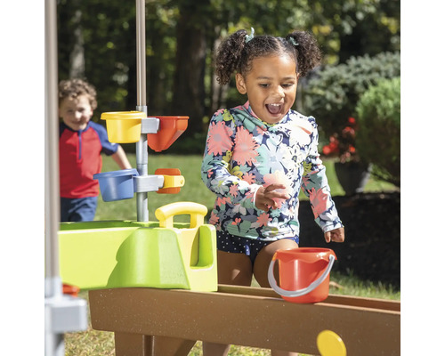 Kind speelt met een waterglijbaan in de openlucht