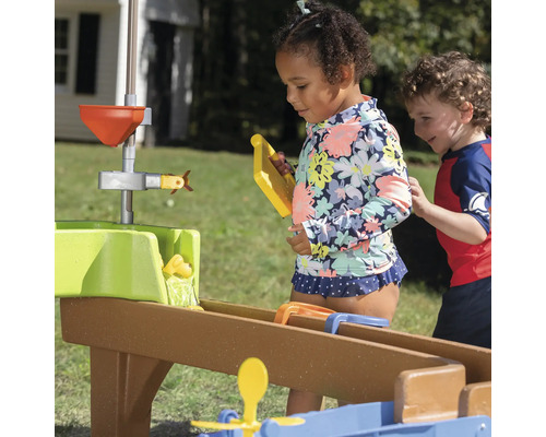 Kinderen spelen met een waterbaansysteem buiten.