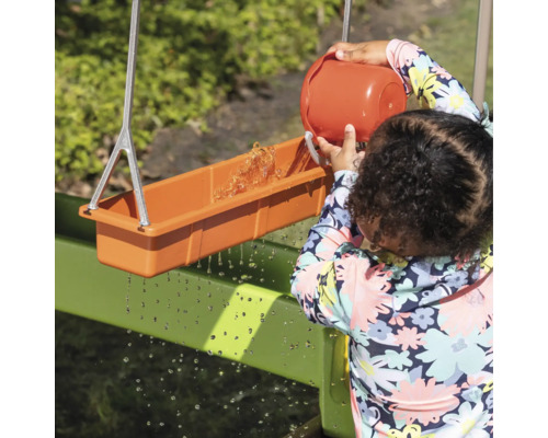 Kind speelt met een watergeul buiten