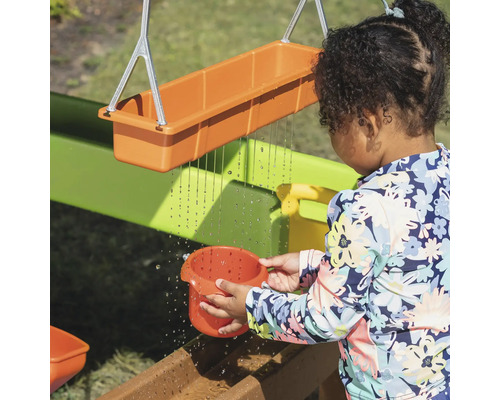 Kind speelt met een waterspeelbaan in de tuin