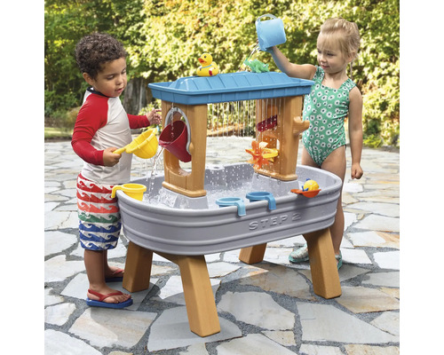 Twee kinderen spelen met een Step2 waterspeeltafel buitenshuis.