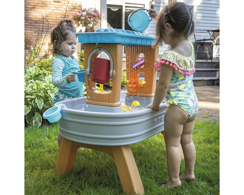 Twee kinderen spelen met een waterspeeltafel buiten.