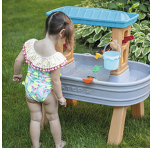 Meisje speelt met Step2 waterspeeltafel in de tuin