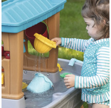 Meisje speelt met een waterspeeltafel met accessoires buiten