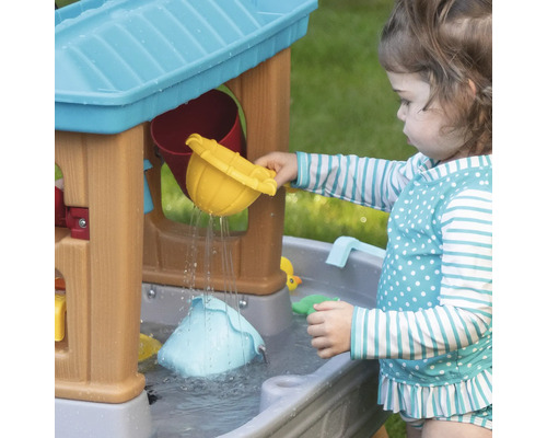 Meisje speelt met een waterspeeltafel met accessoires buiten
