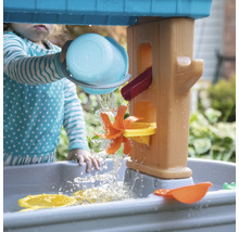Kind speelt met een waterspeeltafel in de tuin