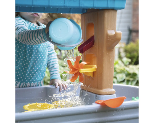 Kind speelt met een waterspeeltafel in de tuin