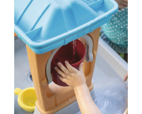 Kind speelt met een waterspeeltafel en een emmer.