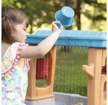 Meisje speelt met waterspeeltafel en een beker