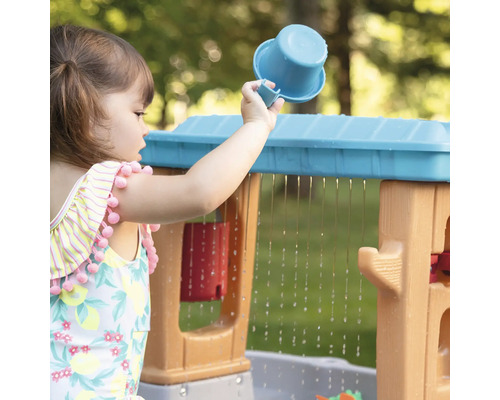 Meisje speelt met waterspeeltafel en een beker