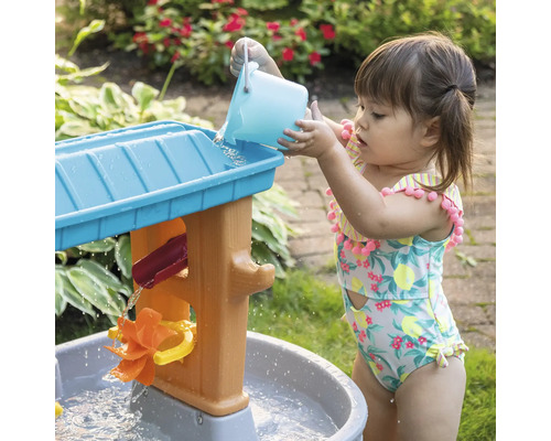Meisje speelt met een Step2 waterspeeltafel in de tuin