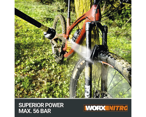 Een mountainbike wordt schoongespoten met een hogedrukreiniger. Worx Nitro logo.