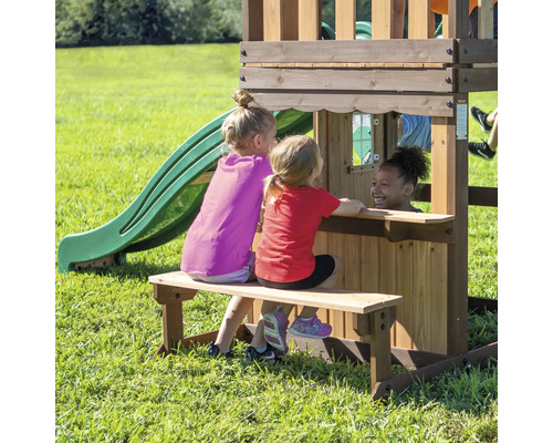 Drie kinderen spelen op een houten speelplaats met glijbaan en zitbank