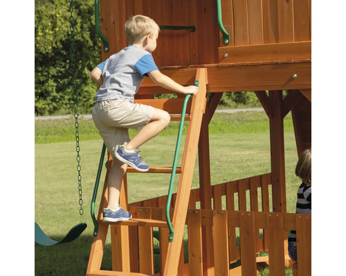 Kind klimt op een houten speeltoestel met ladder.