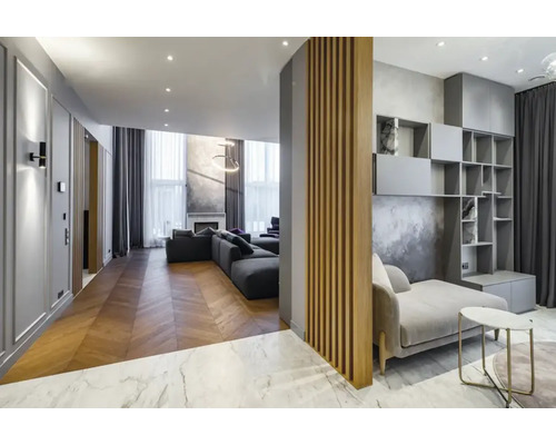 Licht appartement met woonkamer, bank, boekenkast en houten vloer