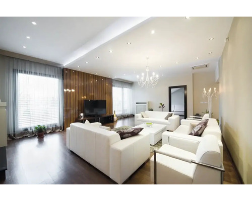 Lichte woonkamer met witte banken, televisie en verlichting