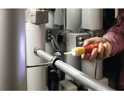 Een persoon gebruikt een inspectiecamera op een pijpleiding in een gebouw.