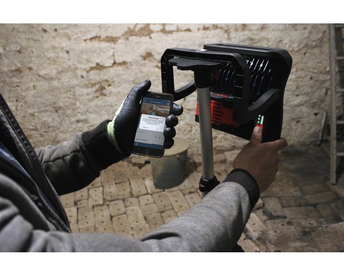 Arbeider bedient LED-bouwlamp met smartphone-app.