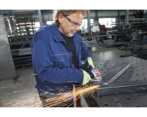 Een man slijpt metaal met een haakse slijper.