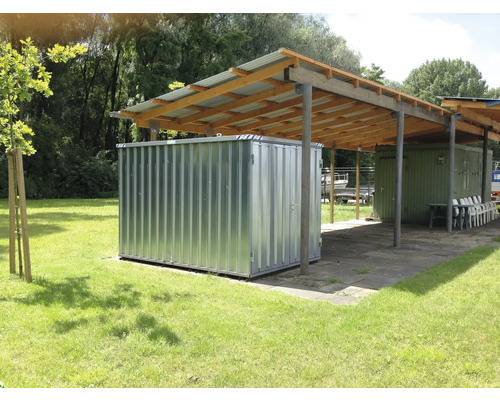 Metalen gereedschapshuis onder een afdak in de buitenlucht