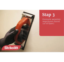 Hand met schuurapparaat tijdens muurbewerking