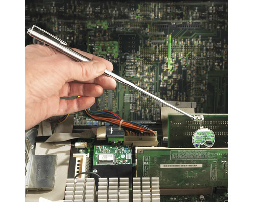 Hand met inspectiespiegel voor een computerprintplaat voor het opsporen van fouten.