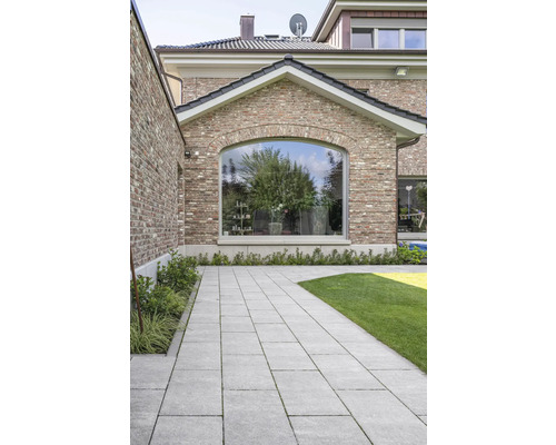 Bestraat pad in de tuin met grasveld