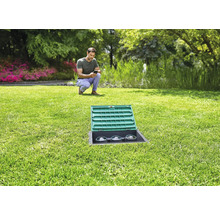 Tuin met irrigatiesysteem en man met mobiele telefoon