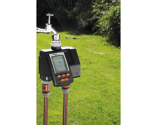 Gardena watercomputer op de kraan met twee tuinslangen in de tuin.