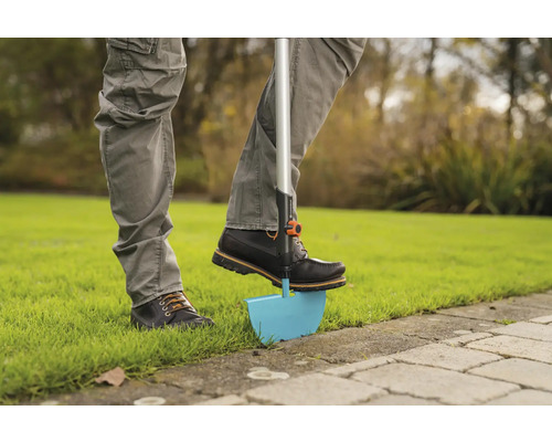 Persoon gebruikt een graskantsteker in de tuin.