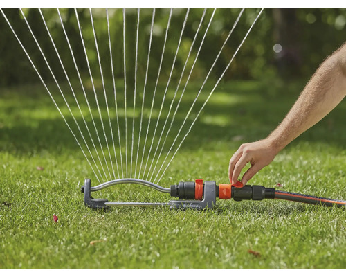 Gazonsproeier besproeit gazon met waterstralen