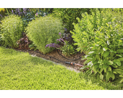 Tuinbewateringssysteem in een beplante tuinborder.