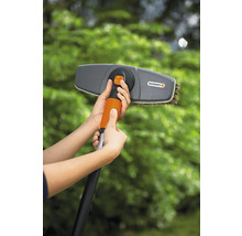 Persoon monteert een Gardena wasborstel op een telescopische stang voor tuinwerkzaamheden.