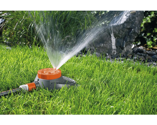 Gazonsproeier sproeit water over gras