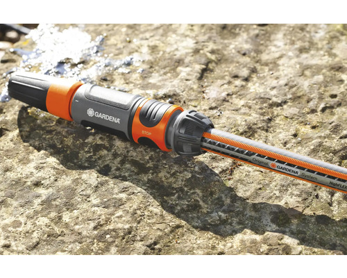 Gardena slangkoppeling met waterslang op een stenen oppervlak