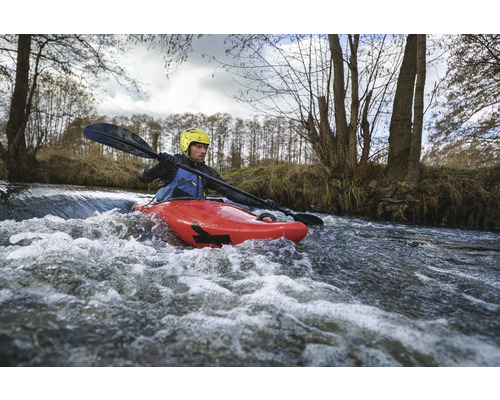 Man in rode kajak met peddel op een rivier