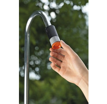 Hand bedient de douchekop van een metalen tuindouche.