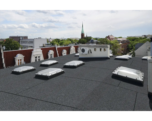 Dak met bitumineuze dakbedekking en dakramen in een stadsbeeld