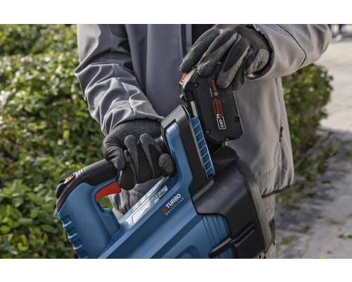 Een persoon plaatst een batterij in een heggenscharen body.